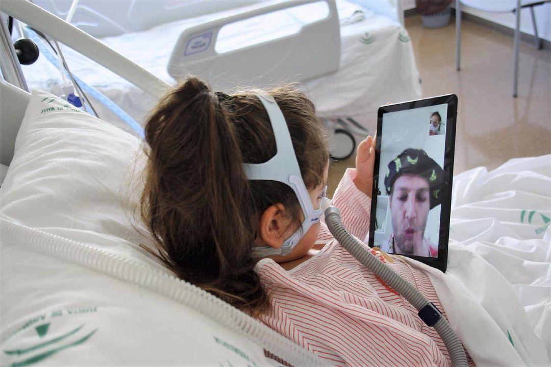 Una niña hospitalizada recibe la viodellamada de uno de los doctores Sonrisa Una niña hospitalizada recibe la viodellamada de uno de los doctores Sonrisa