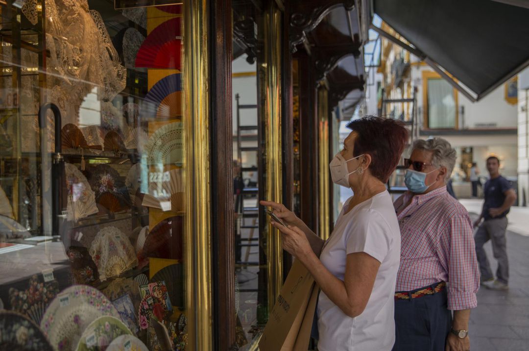 Clientes con mascarilla ante un establecimiento de la calle Sierpes, en Sevilla Clientes con mascarilla ante un establecimiento de la calle Sierpes, en Sevilla
