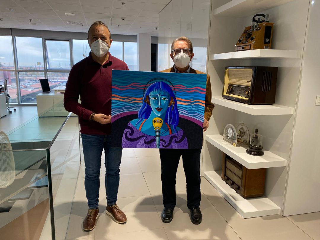 El director de Radio Castellón Cadena Ser posa junto al artista Luis Bolumar sosteniendo la obra 'Locutora en cadena' El director de Radio Castellón Cadena Ser posa junto al artista Luis Bolumar sosteniendo la obra 'Locutora en cadena'
