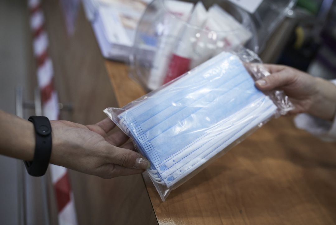 Una farmacéutica enseña un paquete de mascarillas Una farmacéutica enseña un paquete de mascarillas