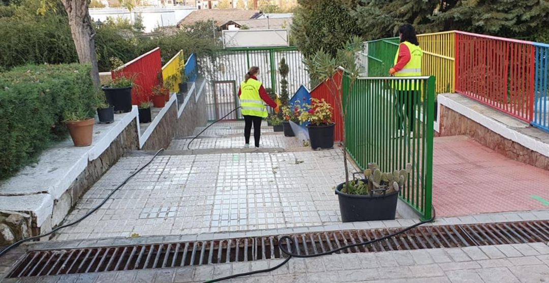 Trabajadoras del Ayuntamiento de Ibros desinfectan la entrada al colegio de la localidad. Trabajadoras del Ayuntamiento de Ibros desinfectan la entrada al colegio de la localidad.