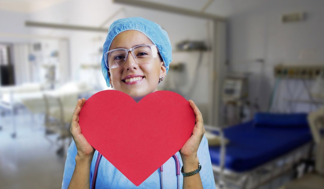 Una enfermera que sujeta un corazón Una enfermera que sujeta un corazón