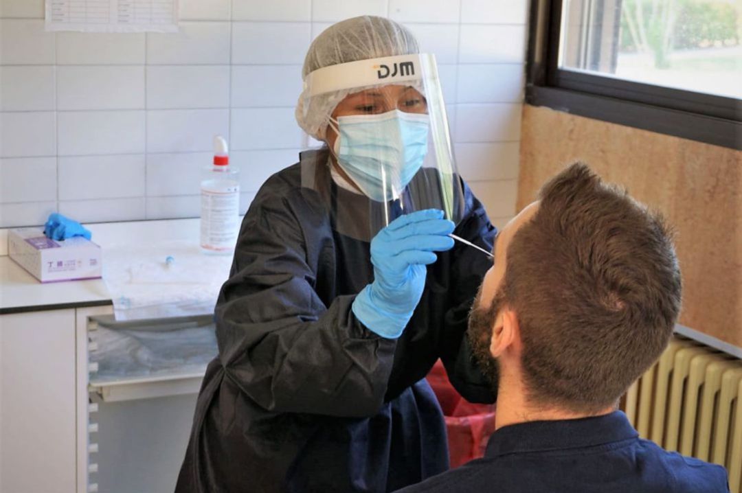Una sanitaria efectua una prueba PCR a un paciente Una sanitaria efectua una prueba PCR a un paciente