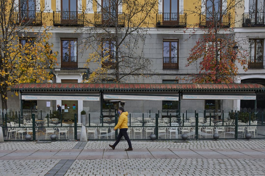Una persona pasea al lado de una mampara instalada en un restaurante de la Plaza de Oriente, en Madrid (España). Una persona pasea al lado de una mampara instalada en un restaurante de la Plaza de Oriente, en Madrid (España).