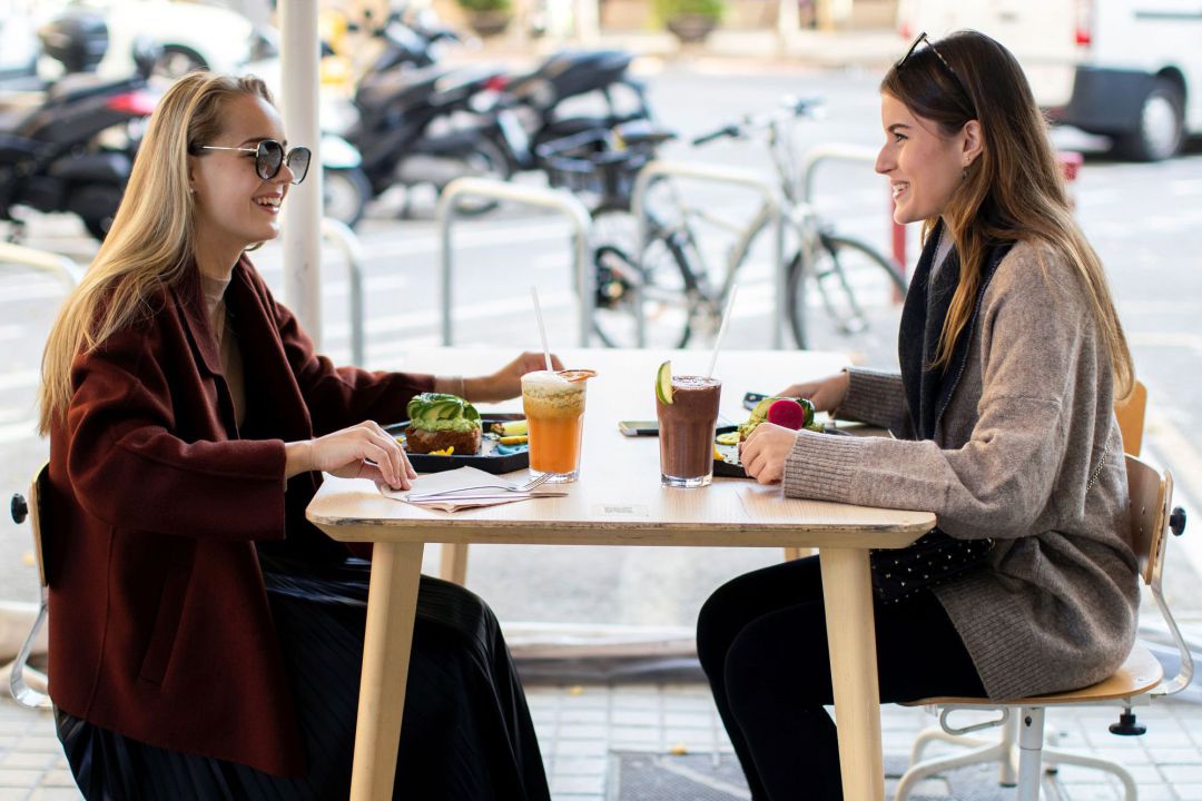 Dos mujeres desayunan en una terraza Dos mujeres desayunan en una terraza