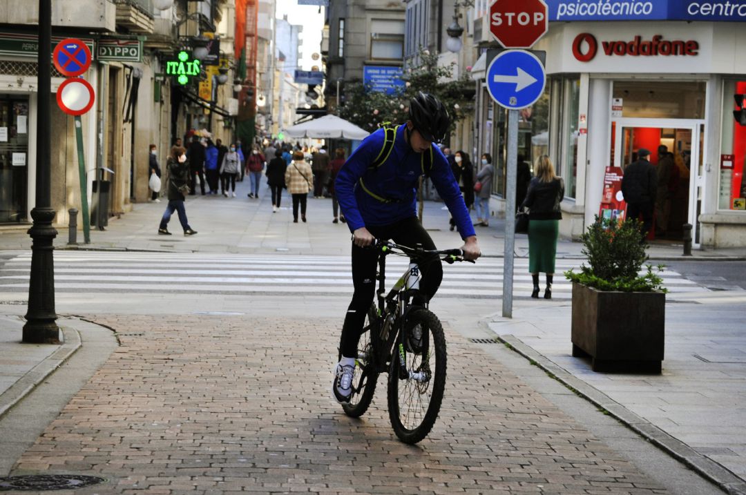 Una persona circula en bicicleta por una vía del centro el mismo día en que se levanta el cierre perimetral del municipio y se reabre la hostelería, en O Carballiño, Ourense. Una persona circula en bicicleta por una vía del centro el mismo día en que se levanta el cierre perimetral del municipio y se reabre la hostelería, en O Carballiño, Ourense.