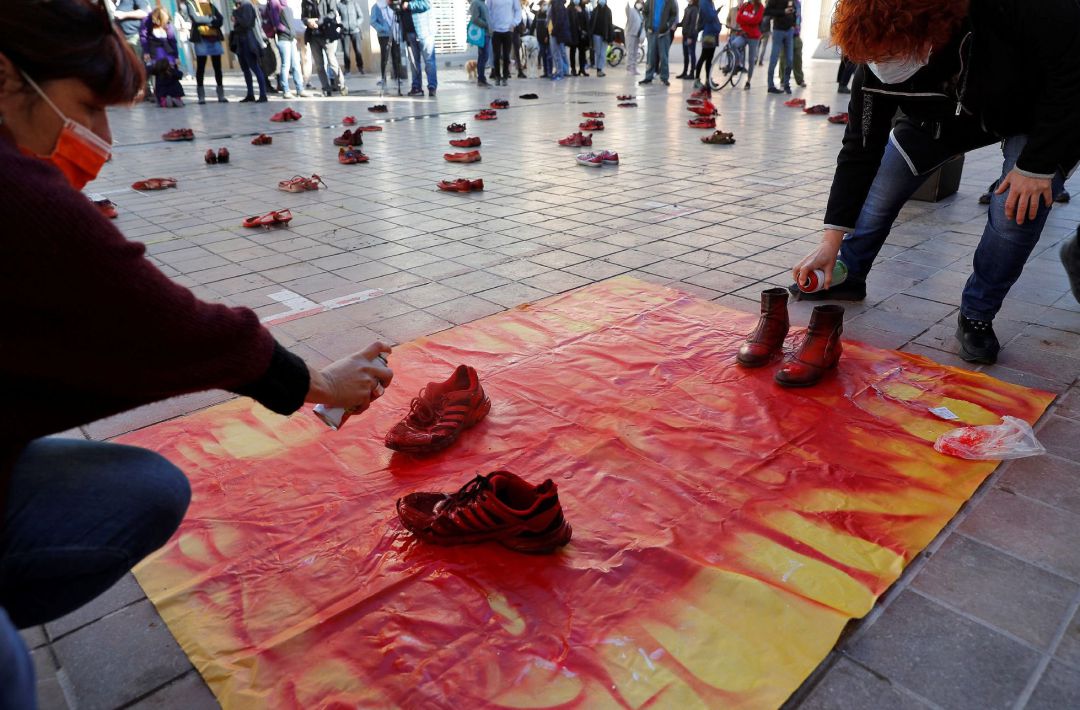 Dos mujeres pintan de rojo dos pares de zapatos en la plaza de Benimaclet de Valencia en una de las acciones y mobilizaciones organizada por la Assemblea Feminista de València con motivo del Día Internacional para la Eliminación de la Violencia contra las Mujeres. Dos mujeres pintan de rojo dos pares de zapatos en la plaza de Benimaclet de Valencia en una de las acciones y mobilizaciones organizada por la Assemblea Feminista de València con motivo del Día Internacional para la Eliminación de la Violencia contra las Mujeres.