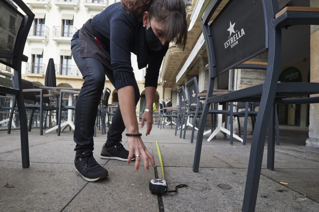 Una mujer prepara la terraza de un bar durante el primer día de la desescalada de la segunda ola del coronavirus Una mujer prepara la terraza de un bar durante el primer día de la desescalada de la segunda ola del coronavirus