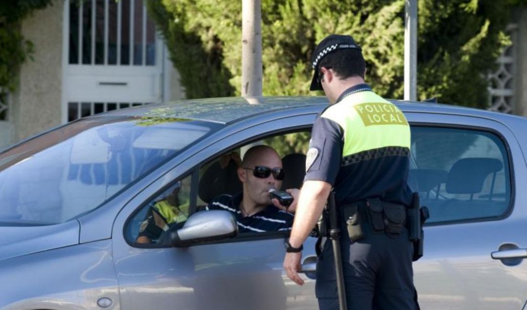 Un agente realiza un control de alcoholemia a un conductor. Un agente realiza un control de alcoholemia a un conductor.