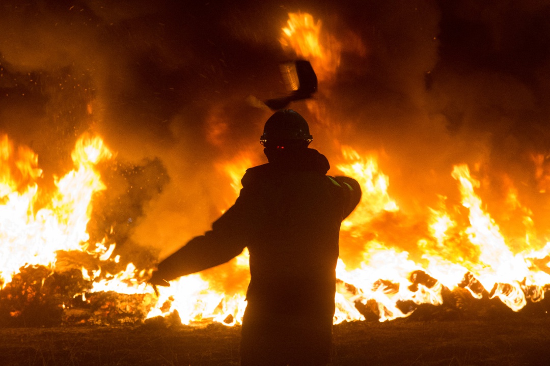Un trabajador tira un elemento a una barricada durante un velatorio nocturno simbólico convocado por la fábrica de Alcoa, en en San Cibrao, A Mariña, Lugo. Un trabajador tira un elemento a una barricada durante un velatorio nocturno simbólico convocado por la fábrica de Alcoa, en en San Cibrao, A Mariña, Lugo.