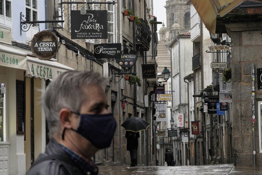 Un hombre camina por una calle con establecimientos cerrados durante el primer día de cierre en la hostelería decretado debido a la crisis del Covid-19, en Santiago de Compostela Un hombre camina por una calle con establecimientos cerrados durante el primer día de cierre en la hostelería decretado debido a la crisis del Covid-19, en Santiago de Compostela