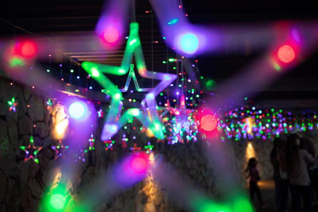 Una familia bajo las luces durante el Festival anual de luces en los Jardines Botánicos Waler Sisulu en la navidad en Johannesburgo, Sudáfrica. Una familia bajo las luces durante el Festival anual de luces en los Jardines Botánicos Waler Sisulu en la navidad en Johannesburgo, Sudáfrica.
