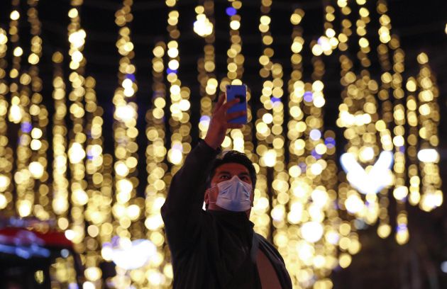 Una persona se fotografía con las luces de navidad del centro de Barcelona este lunes. Una persona se fotografía con las luces de navidad del centro de Barcelona este lunes.