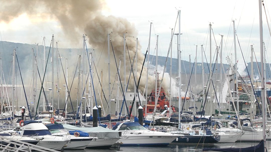 Puerto de Bouzas con el barco ardiendo al fondo Puerto de Bouzas con el barco ardiendo al fondo