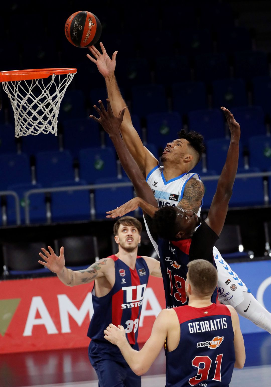 Echenique entra a canasta ante la oposición de dos jugadores de Baskonia Echenique entra a canasta ante la oposición de dos jugadores de Baskonia