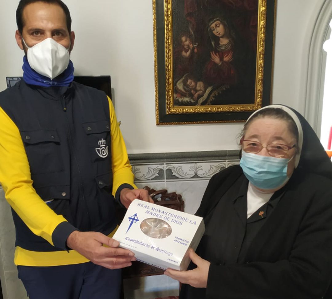 Un empleado de Correos recoge de una de las madres del monasterio de las Comendadoras de Santiago de Granada una de las cajas con sus dulces de Navidad para enviarla por el servicio de paquetería de la empresa estatal Un empleado de Correos recoge de una de las madres del monasterio de las Comendadoras de Santiago de Granada una de las cajas con sus dulces de Navidad para enviarla por el servicio de paquetería de la empresa estatal