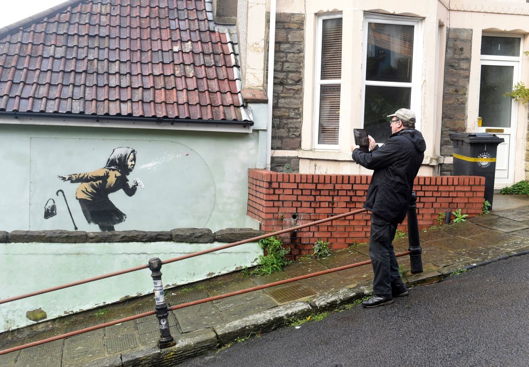 Un hombre fotografía la última obra de Banksy, llamada 'Aachoo!!', en Bristol (Reino Unido). Un hombre fotografía la última obra de Banksy, llamada 'Aachoo!!', en Bristol (Reino Unido).