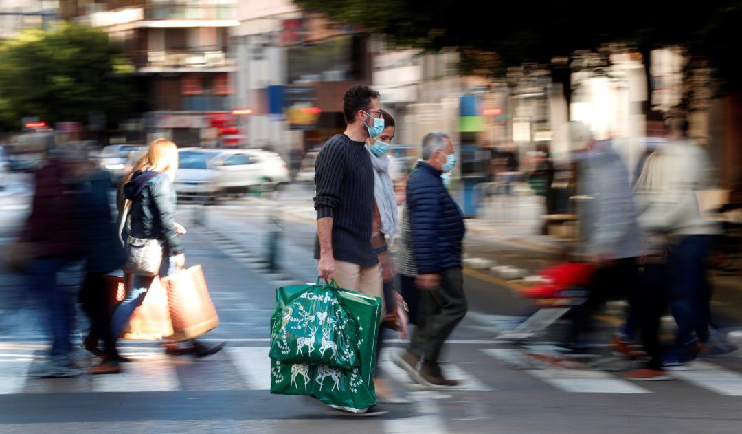 Varias personas cargan con sus bolsas tras realizar sus compras este domingo a menos de dos semanas de celebrarse la navidad. Varias personas cargan con sus bolsas tras realizar sus compras este domingo a menos de dos semanas de celebrarse la navidad.