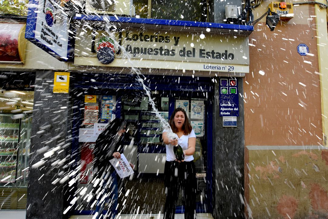 Una mujer celebra con cava un cuarto premio de la Lotería de Navidad frente a la Administración número 29 de L'Hospitalet de Llobregat (Barcelona), en 2018. Una mujer celebra con cava un cuarto premio de la Lotería de Navidad frente a la Administración número 29 de L'Hospitalet de Llobregat (Barcelona), en 2018.