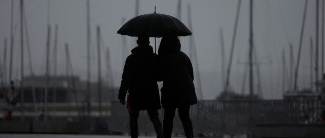 Dos personas caminan bajo la lluvia en la ciudad de A Coruña Dos personas caminan bajo la lluvia en la ciudad de A Coruña