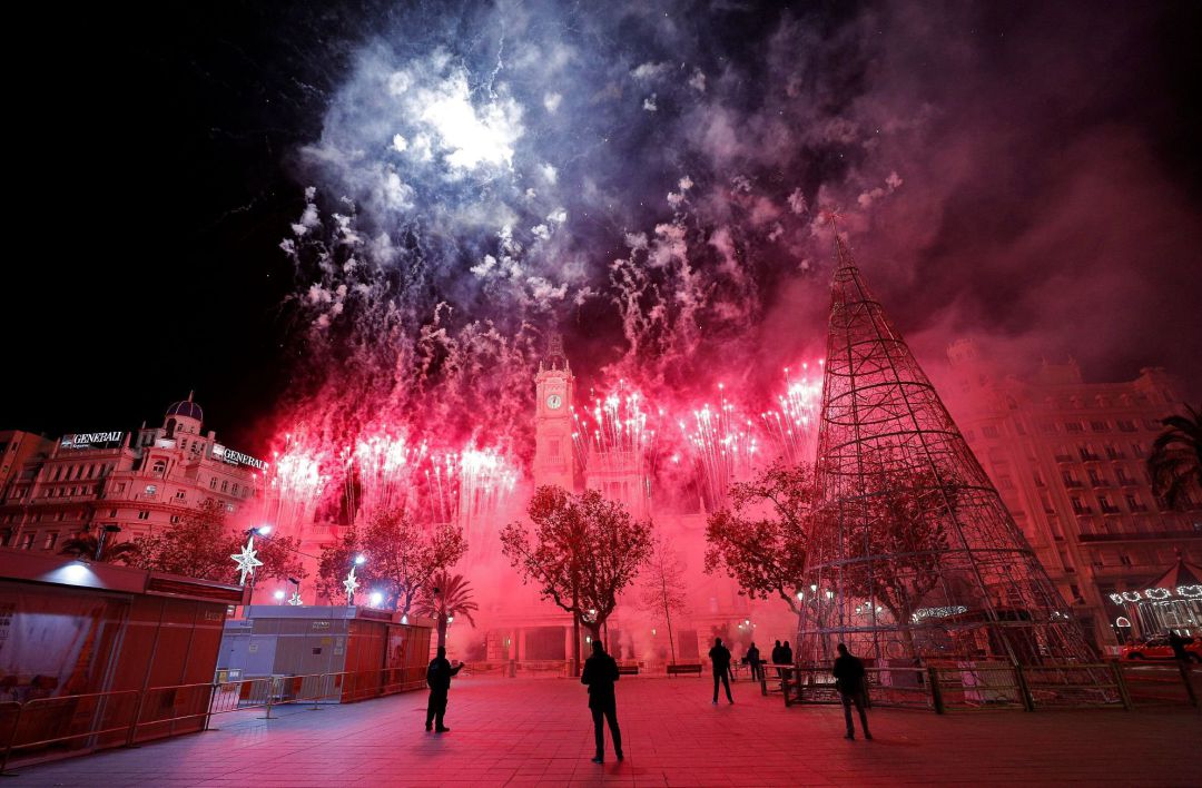 Un numeroso dispositivo de agentes de la Policía Local ha vigilado la plaza del Ayuntamiento de Valencia para impedir el acceso tras la prohibición de celebrar la Nochevieja en la misma dadas las restricciones por la pandemia. En la imagen un momento del castillo de fuegos artificiales disparado este medianoche Un numeroso dispositivo de agentes de la Policía Local ha vigilado la plaza del Ayuntamiento de Valencia para impedir el acceso tras la prohibición de celebrar la Nochevieja en la misma dadas las restricciones por la pandemia. En la imagen un momento del castillo de fuegos artificiales disparado este medianoche