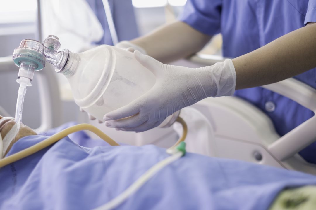Un sanitario poniendo oxígeno a un paciente Un sanitario poniendo oxígeno a un paciente