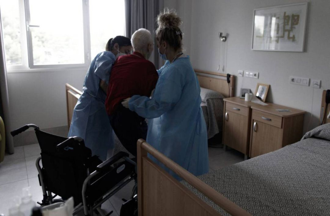Sanitarias ayudan a un anciano en un centro de mayores. Sanitarias ayudan a un anciano en un centro de mayores.