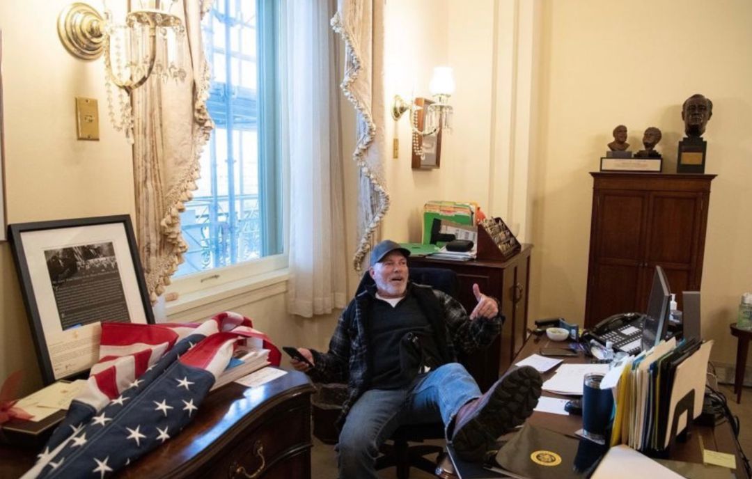 Un manifestante con los pies encima de la mesa de la presidenta de la Cámara de los Representantes. Un manifestante con los pies encima de la mesa de la presidenta de la Cámara de los Representantes.