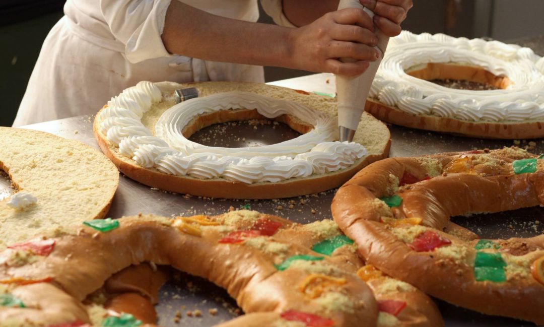Un pastelero rellenando de nata uno de los roscones solidarios Un pastelero rellenando de nata uno de los roscones solidarios