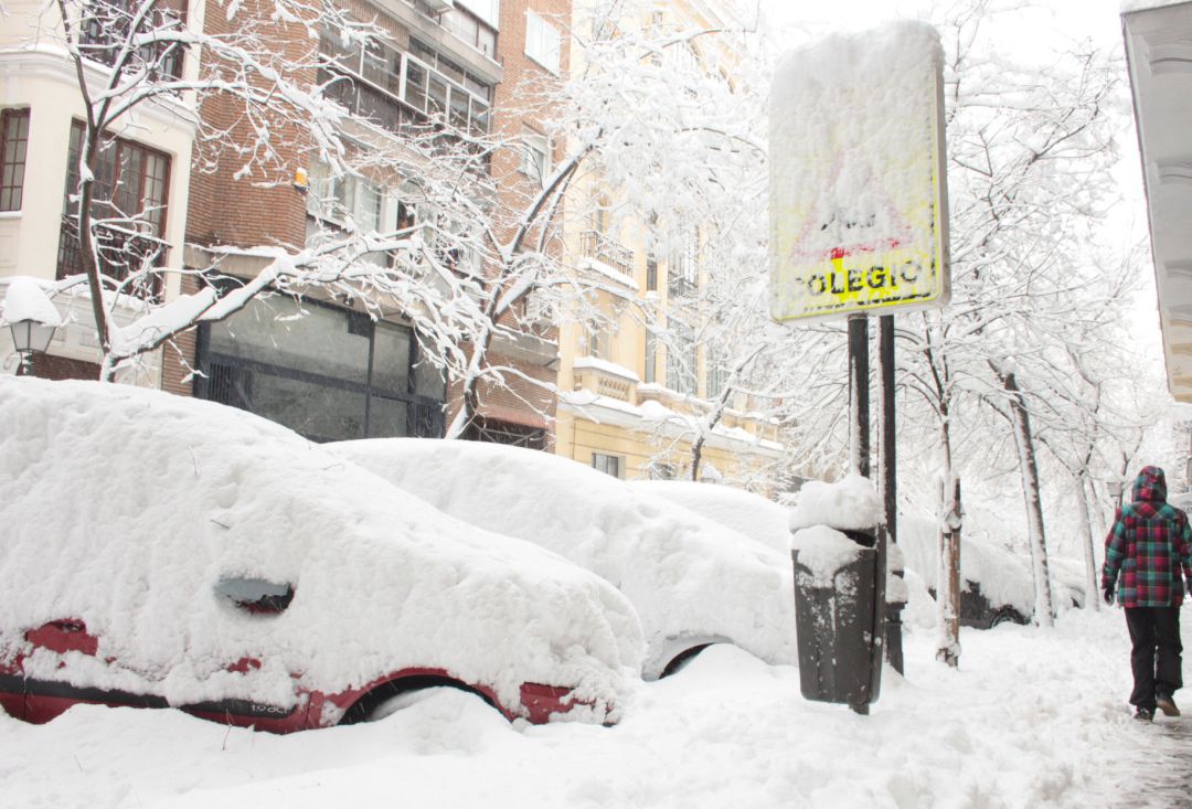 Una persona pasea por una céntrica calle cubierta de nieve junto al acceso de un colegio en Madrid (España) a 9 de enero de 2021. Una persona pasea por una céntrica calle cubierta de nieve junto al acceso de un colegio en Madrid (España) a 9 de enero de 2021.
