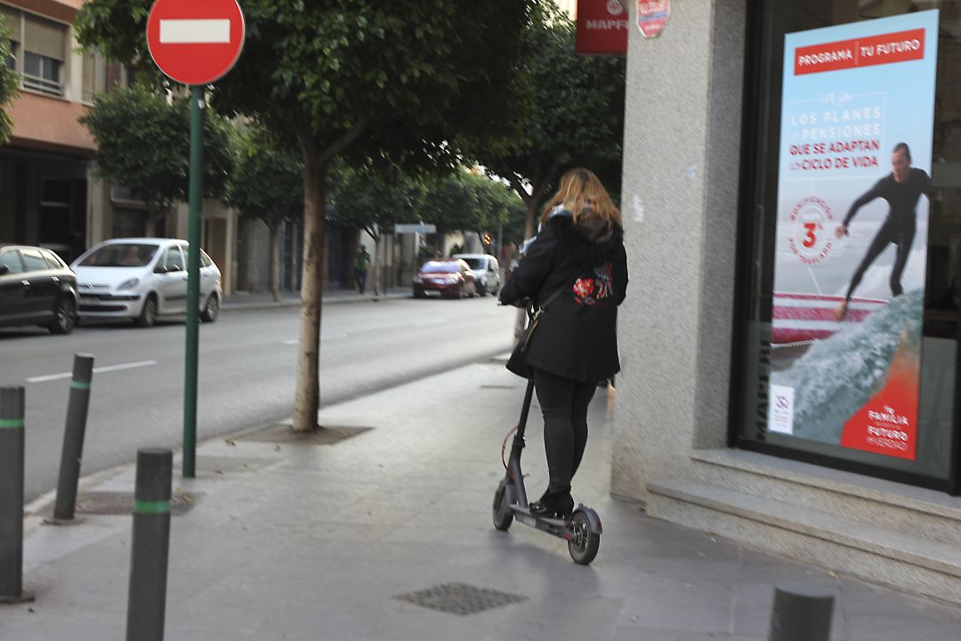 Patinete por la acera. Imagen de archivo Patinete por la acera. Imagen de archivo