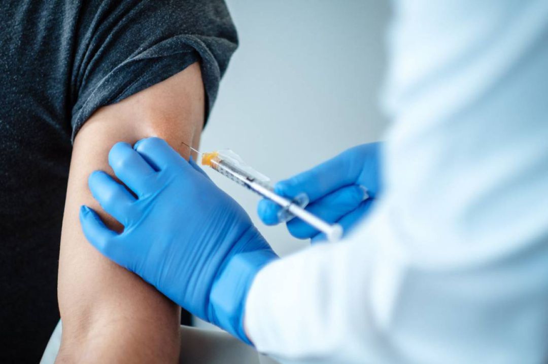Un sanitario administrando una dosis de la vacuna Un sanitario administrando una dosis de la vacuna