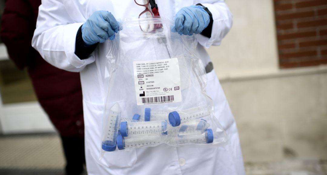 Un sanitario con tubos de ensayo durante la realización de tests de RT-PCR Un sanitario con tubos de ensayo durante la realización de tests de RT-PCR