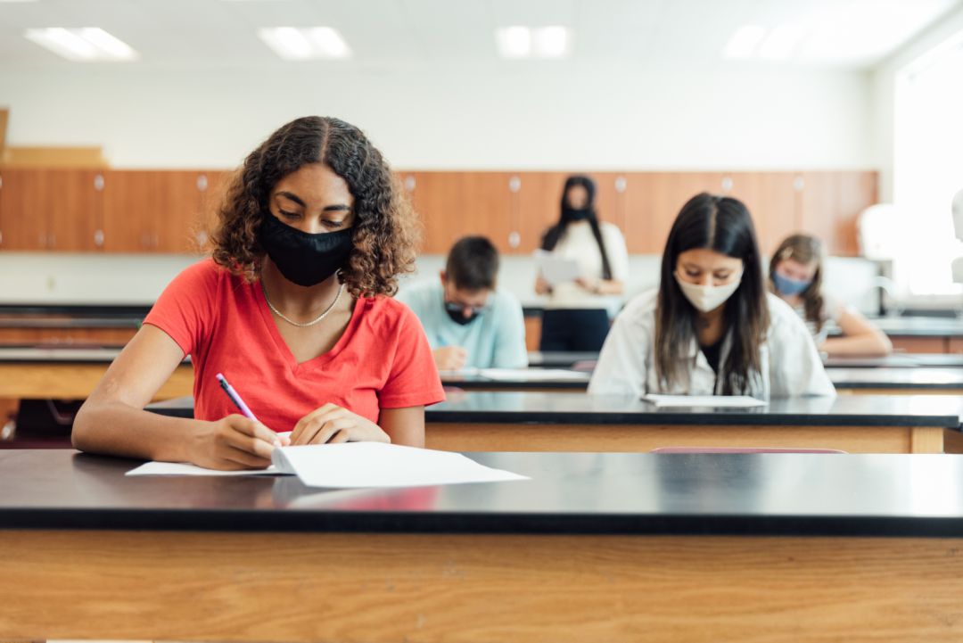 Estudiantes realizando un examen con mascarilla Estudiantes realizando un examen con mascarilla