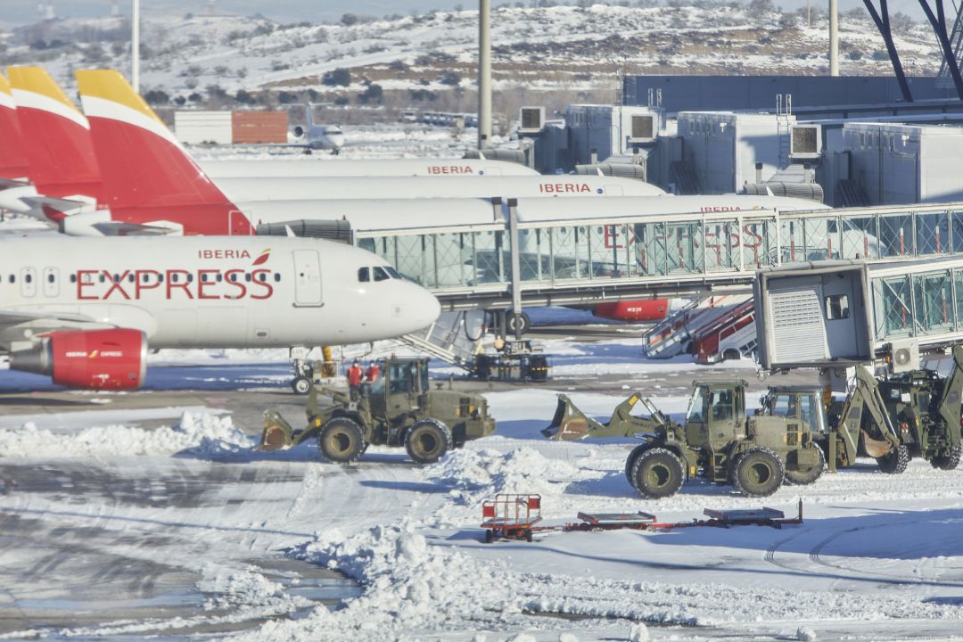 Varias excavadoras de la Unidad Militar de Emergencias (UME) trabajan para quitar la nieve y el hielo de la pista del aeropuerto Madrid-Barajas Adolfo Suárez Varias excavadoras de la Unidad Militar de Emergencias (UME) trabajan para quitar la nieve y el hielo de la pista del aeropuerto Madrid-Barajas Adolfo Suárez