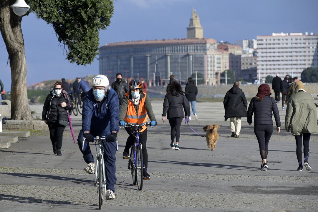 Varias personas caminan por un paseo marítimo en A Coruña Varias personas caminan por un paseo marítimo en A Coruña