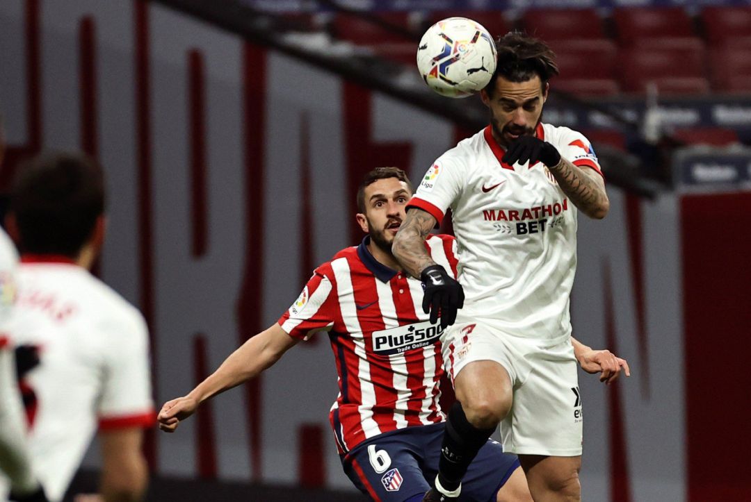 El delantero del Sevilla FC Suso cabecea delante de Koke Resurrección. El delantero del Sevilla FC Suso cabecea delante de Koke Resurrección.