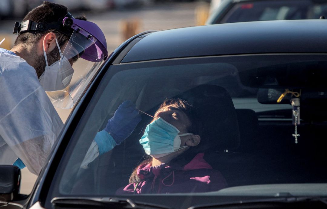 Un sanitario realiza test para detectar la covid-19 a pacientes en sus vehículos frente al hospital Un sanitario realiza test para detectar la covid-19 a pacientes en sus vehículos frente al hospital