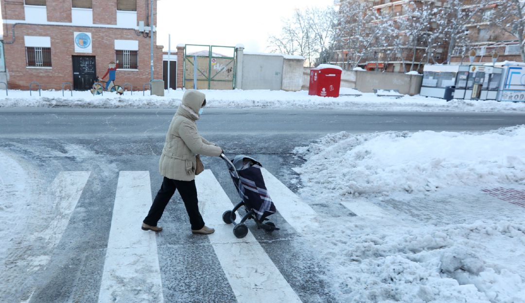 Una mujer camina con un carro de la compra por una vía nevada de Teruel. Una mujer camina con un carro de la compra por una vía nevada de Teruel.