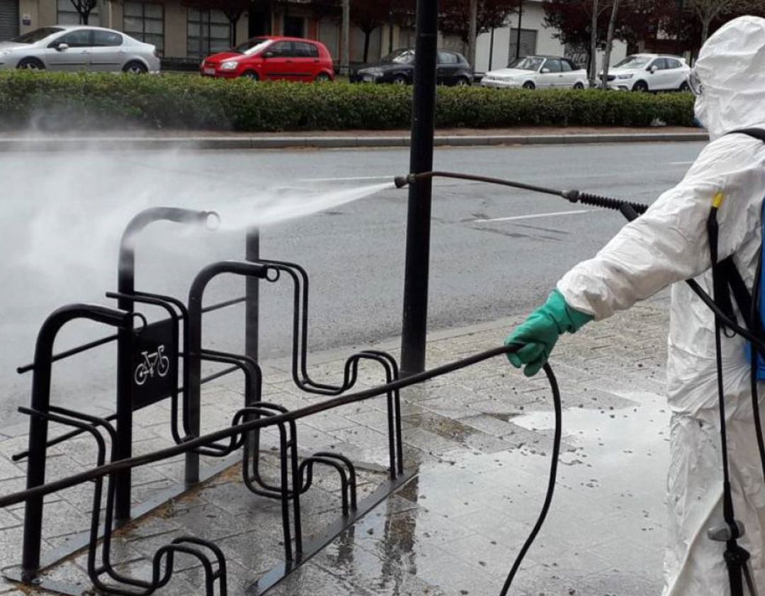 Un operario desinfectando mobiliario urbano Un operario desinfectando mobiliario urbano