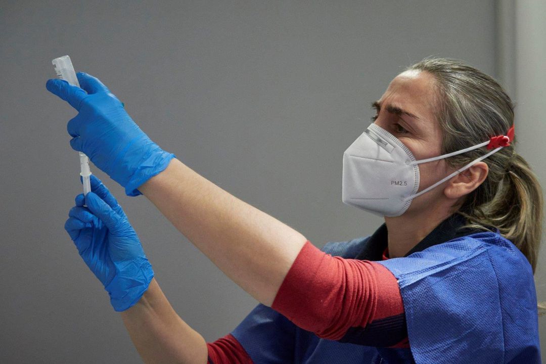 Una trabajadora sanitaria administra la vacuna Una trabajadora sanitaria administra la vacuna