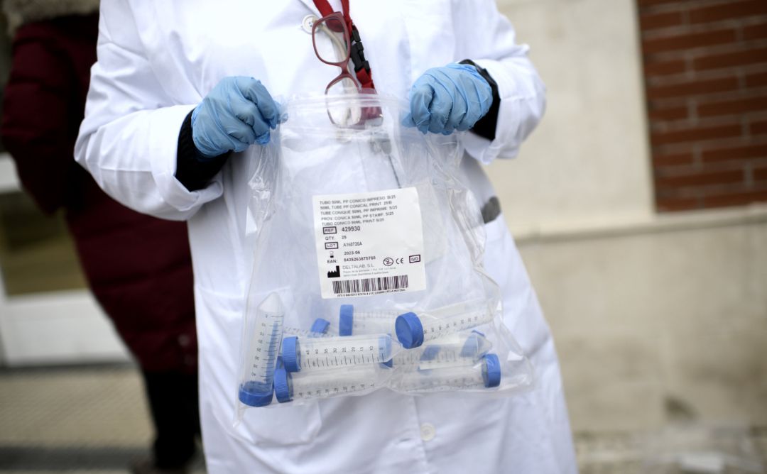 Un sanitario con tubos de ensayo durante la realización de tests de RT-PCR Un sanitario con tubos de ensayo durante la realización de tests de RT-PCR