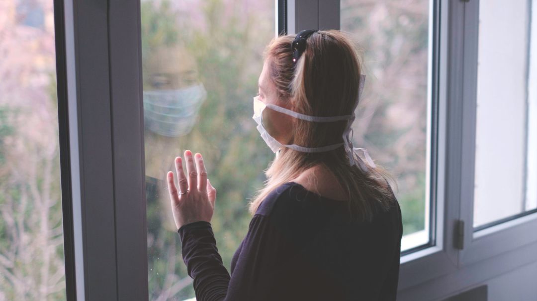 Imagen de una persona asomándose a una ventana Imagen de una persona asomándose a una ventana