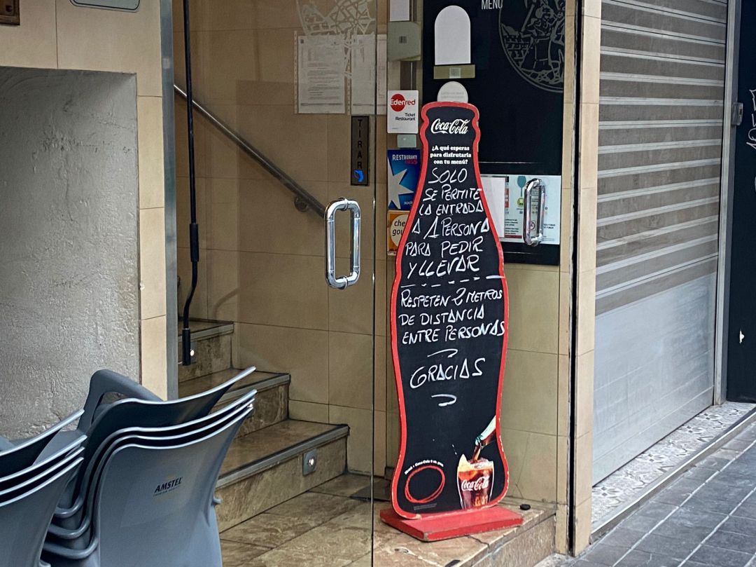 Cartel frente a un restaurante en València que abre solo con comida para llevar Cartel frente a un restaurante en València que abre solo con comida para llevar