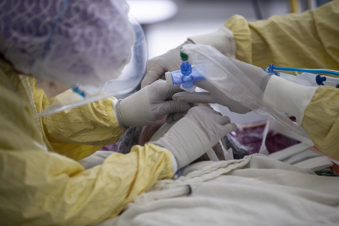Personal sanitario coloca un respirador a un paciente de coronavirus Personal sanitario coloca un respirador a un paciente de coronavirus