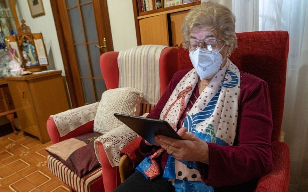 Una señora maneja una tablet en su domicilio. Una señora maneja una tablet en su domicilio.