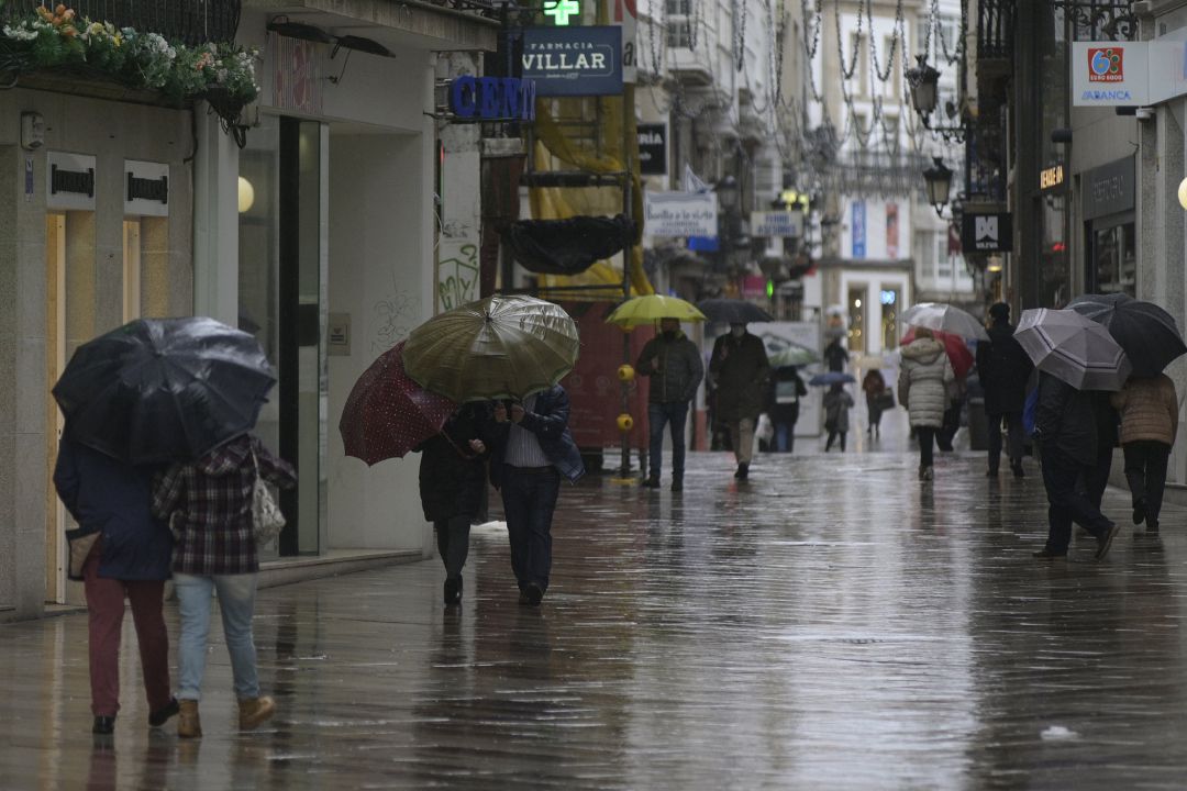 Transeúntes caminan protegidos por una vía de A Coruña, Galicia, a 20 de enero de 2021. Transeúntes caminan protegidos por una vía de A Coruña, Galicia, a 20 de enero de 2021.