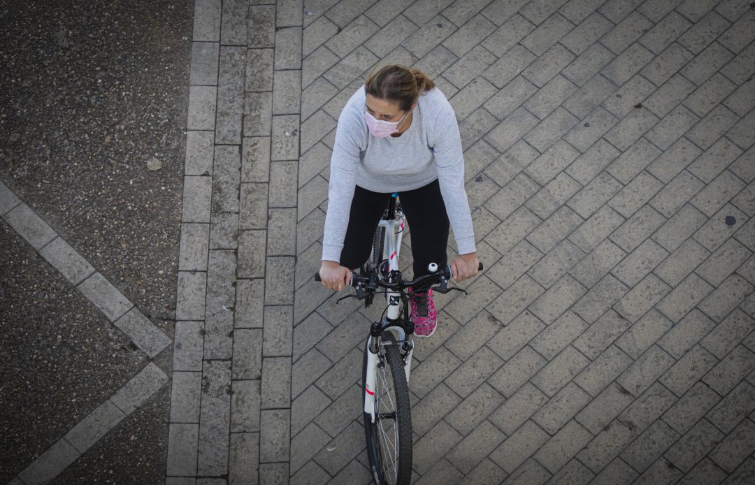 Una mujer con mascarilla montando en bicicleta, en una imagen de archivo Una mujer con mascarilla montando en bicicleta, en una imagen de archivo