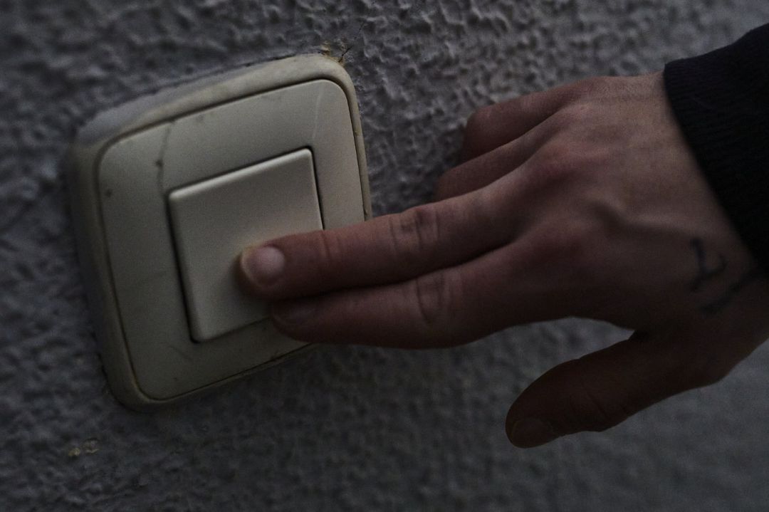 Un hombre toca un interruptor de luz. Un hombre toca un interruptor de luz.