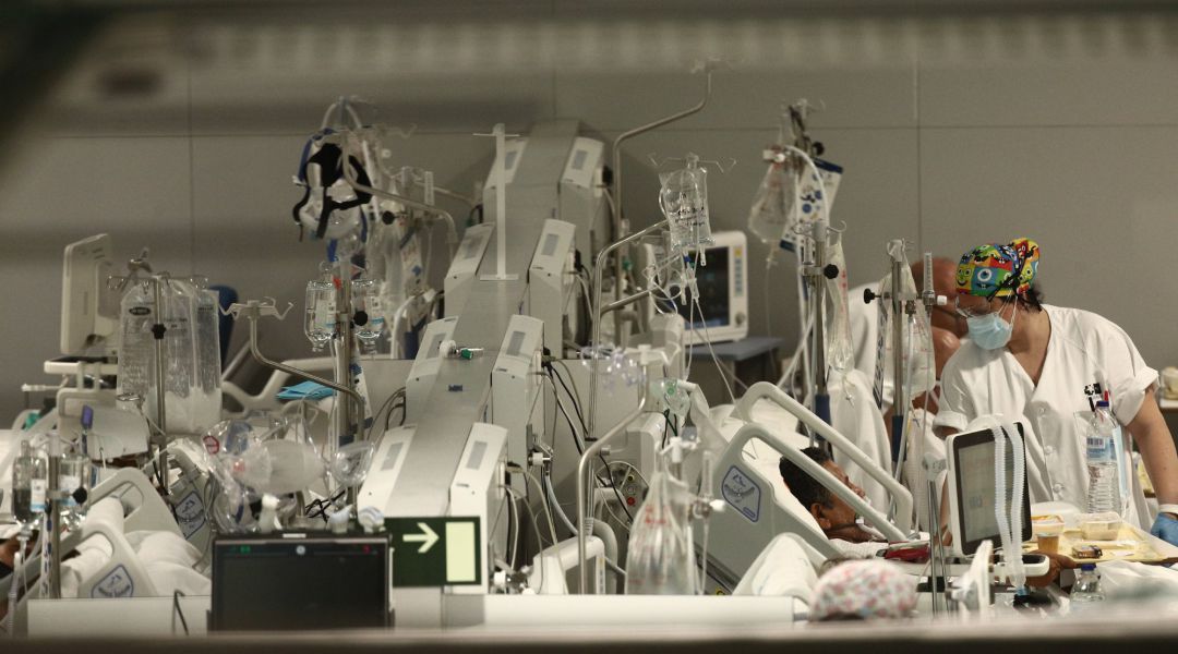 Una enfermera trata a un enfermo en el Hospital de Emergencias Isabel Zendal. El hospital, inaugurado el pasado 1 de diciembre, ha superado ya los 801 pacientes de COVID-19 y los ingresados en la Unidad de Cuidados Una enfermera trata a un enfermo en el Hospital de Emergencias Isabel Zendal. El hospital, inaugurado el pasado 1 de diciembre, ha superado ya los 801 pacientes de COVID-19 y los ingresados en la Unidad de Cuidados